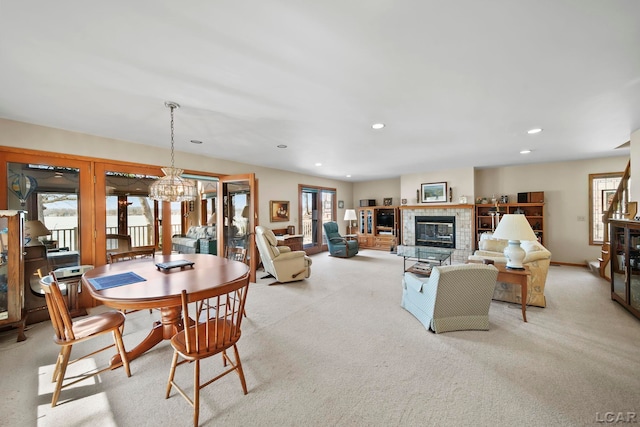 carpeted dining space featuring recessed lighting, baseboards, an inviting chandelier, and a glass covered fireplace