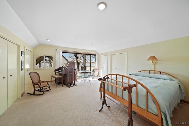 bedroom with lofted ceiling, carpet flooring, recessed lighting, and two closets