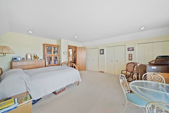 carpeted bedroom with lofted ceiling, recessed lighting, and multiple closets