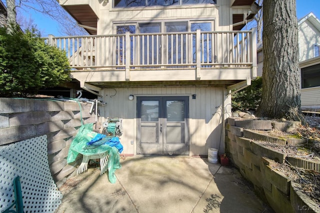 rear view of property featuring a balcony, a patio area, and french doors