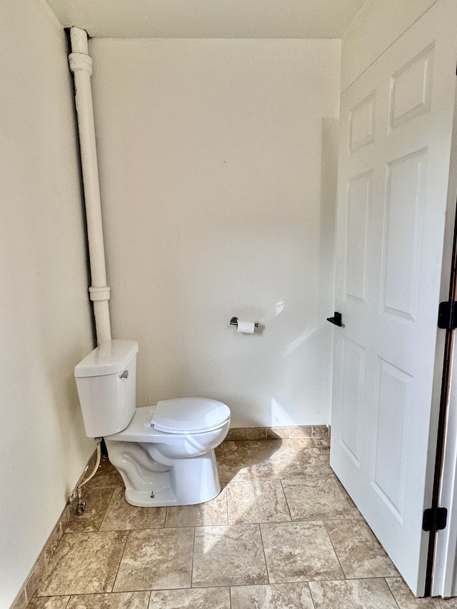 bathroom featuring stone finish flooring and toilet