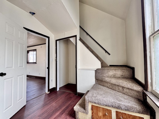 stairs featuring vaulted ceiling, wood finished floors, and baseboards