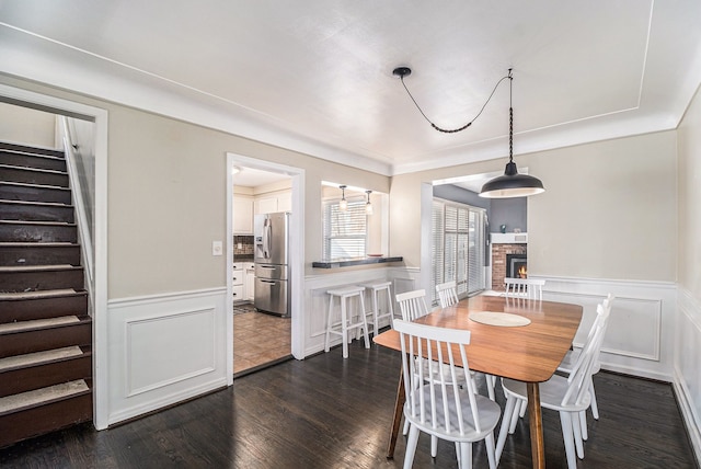 3018 Guilford Dr, Royal Oak, MI 48073 - dining area featuring stairs, a fireplace, wainscoting, dark wood finished floors, and a decorative wall