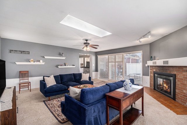 3018 Guilford Dr, Royal Oak, MI 48073 - living area with carpet flooring, a skylight, a brick fireplace, and a ceiling fan