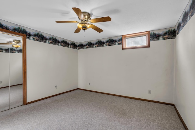 below grade area with ceiling fan, baseboards, and carpet