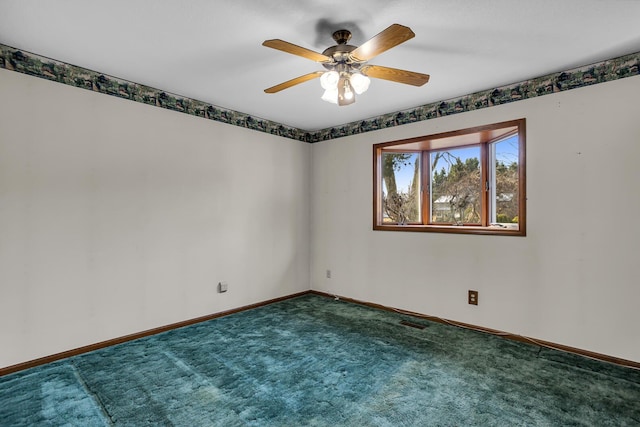 empty room featuring carpet flooring, a ceiling fan, visible vents, and baseboards