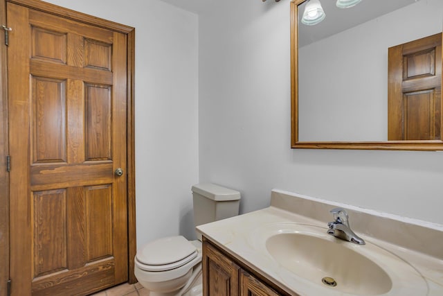 half bathroom featuring vanity, tile patterned floors, and toilet