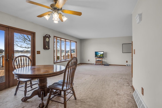 carpeted dining room with visible vents, french doors, and baseboards