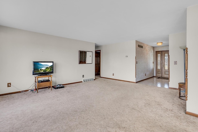 unfurnished living room with visible vents, baseboards, and light colored carpet