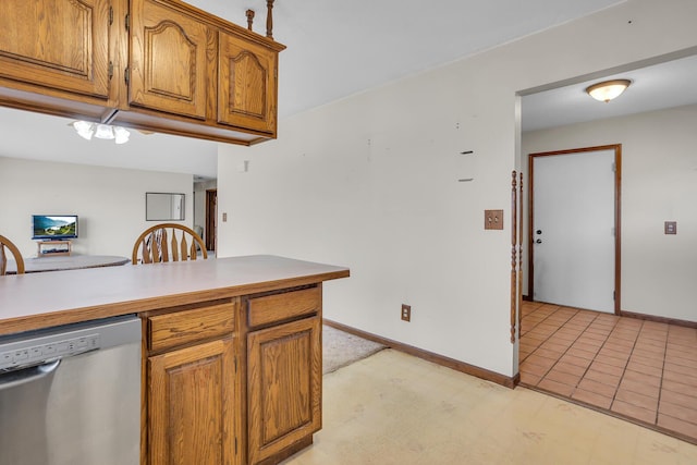 kitchen with baseboards, brown cabinets, dishwasher, and light countertops