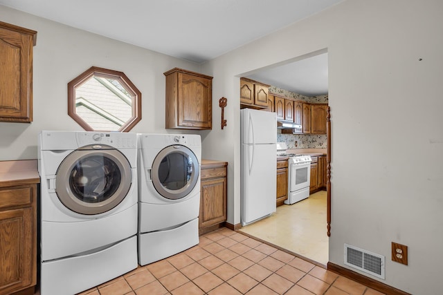 laundry room with laundry area, light floors, visible vents, and washer and clothes dryer