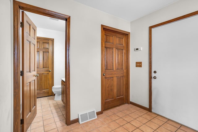 foyer entrance featuring light tile patterned floors, visible vents, and baseboards