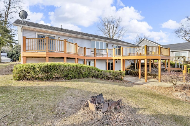 rear view of house with a lawn and a wooden deck