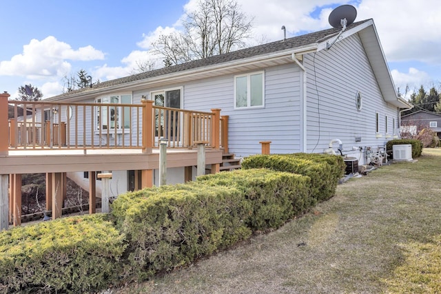 rear view of property featuring a yard and a deck