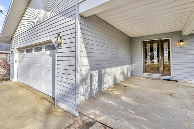 doorway to property with a garage and driveway