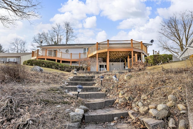 rear view of house featuring stairway and a deck