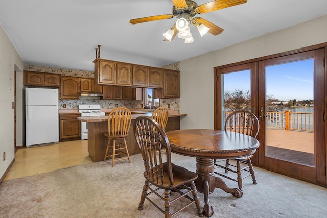 dining area with french doors, light colored carpet, and a ceiling fan