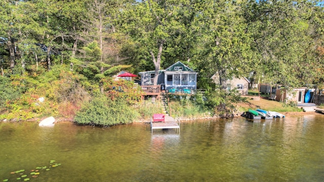 birds eye view of property featuring a forest view and a water view