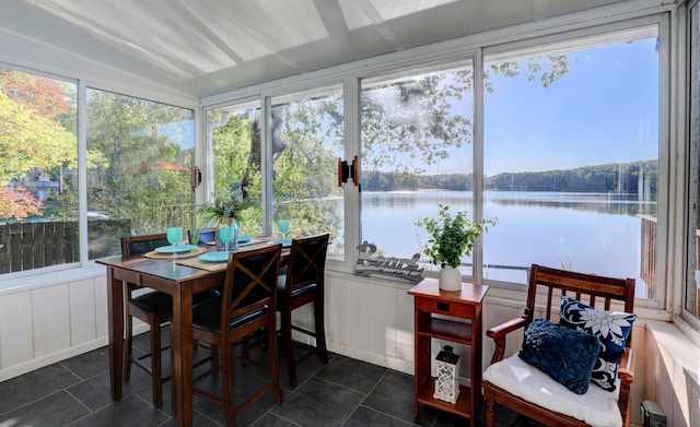 sunroom featuring a water view