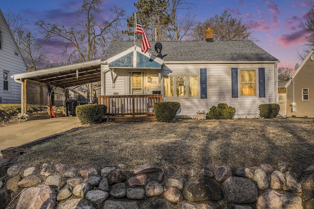 view of front of house featuring a carport, covered porch, concrete driveway, and a chimney