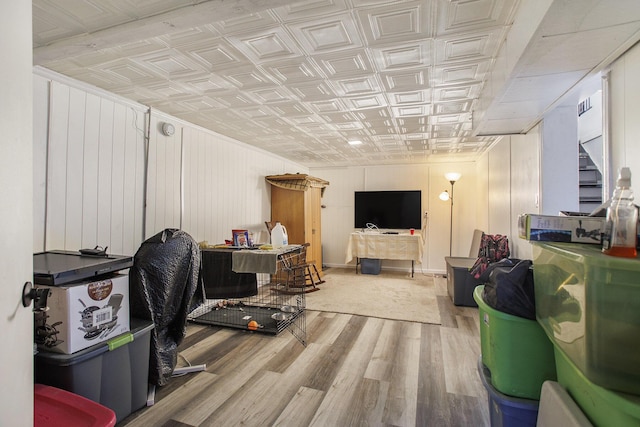 below grade area with stairway, an ornate ceiling, and wood finished floors