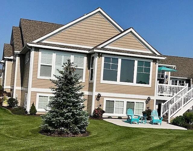 rear view of property with a lawn, stairs, and a patio area