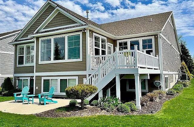 rear view of house with a yard, a wooden deck, stairs, and a patio