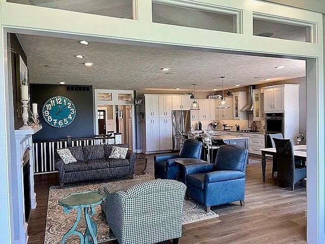 living room featuring recessed lighting, light wood-style flooring, and a textured ceiling