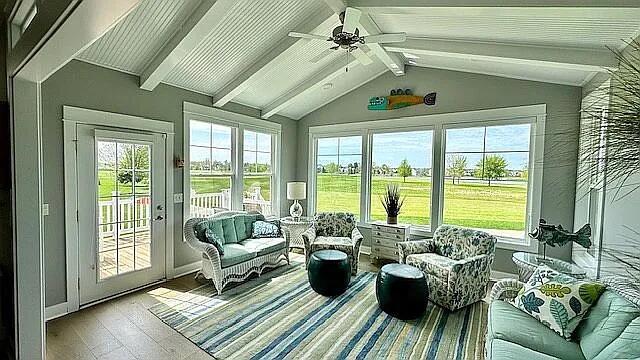 sunroom featuring lofted ceiling with beams and a ceiling fan