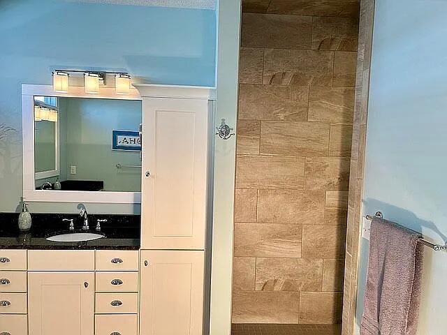 bathroom featuring vanity and a tile shower