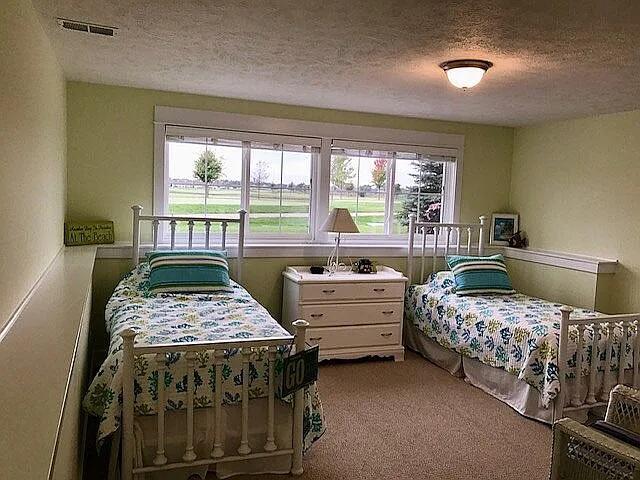 bedroom with visible vents, a textured ceiling, and carpet