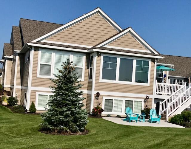 back of property featuring a patio area and a lawn