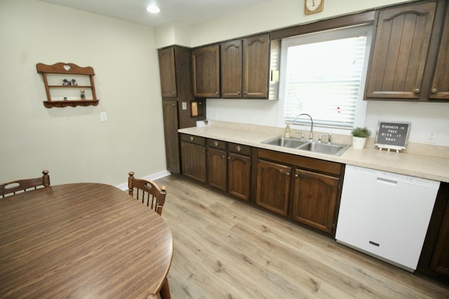 kitchen featuring dishwasher, light countertops, light wood-style flooring, and a sink