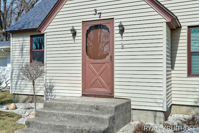 entrance to property with roof with shingles