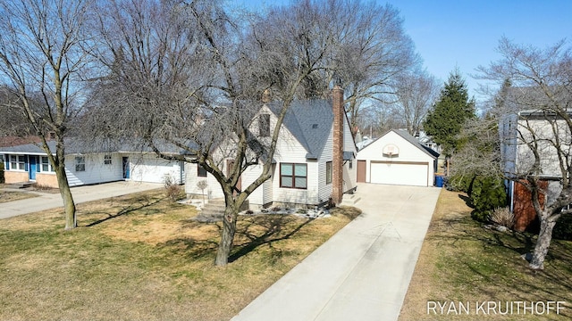 view of front facade with a shingled roof, a front yard, a chimney, a garage, and driveway