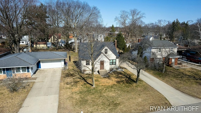 view of front of property with concrete driveway, a garage, a front lawn, and a residential view