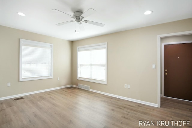 unfurnished room with wood finished floors, visible vents, baseboards, and ceiling fan