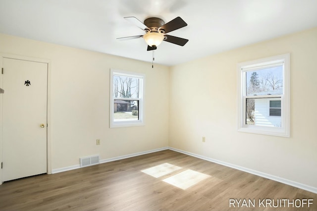 spare room with visible vents, baseboards, a ceiling fan, and wood finished floors