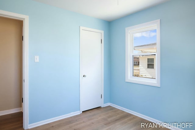 unfurnished bedroom featuring a closet, baseboards, and wood finished floors