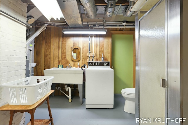 interior space featuring a sink, washer / clothes dryer, and wooden walls