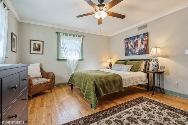 bedroom with light wood-type flooring, visible vents, baseboards, and crown molding