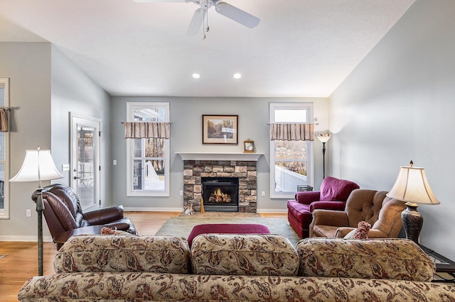 living area with a ceiling fan, a healthy amount of sunlight, light wood-type flooring, and baseboards