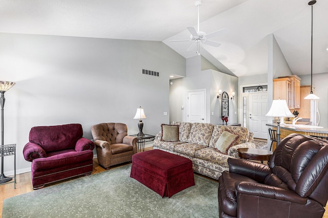 living room featuring visible vents, high vaulted ceiling, wood finished floors, baseboards, and ceiling fan