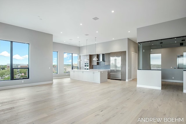 unfurnished living room featuring a wealth of natural light, recessed lighting, and light wood-style floors