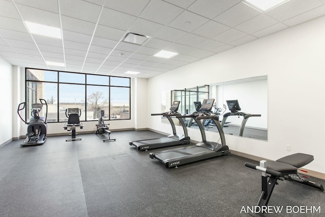 gym featuring visible vents, a paneled ceiling, and baseboards