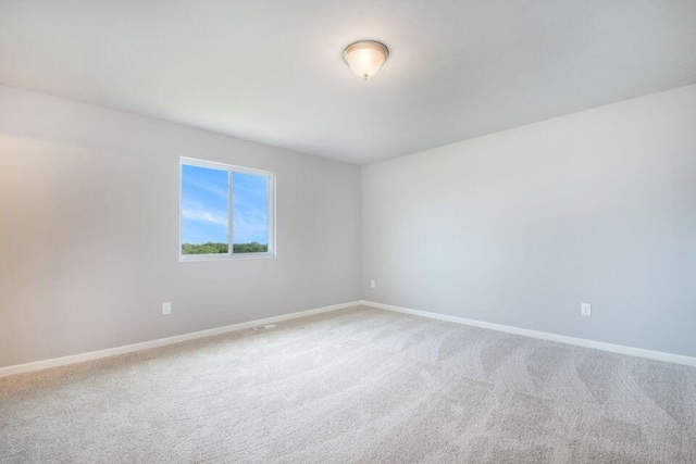 spare room featuring baseboards and carpet floors