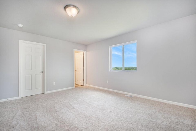 empty room featuring baseboards and carpet