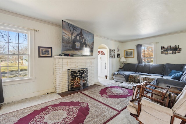 living room with a wealth of natural light, arched walkways, and ornamental molding