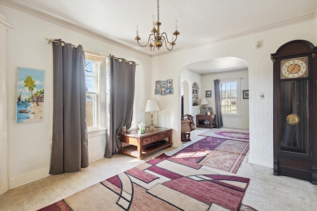 carpeted foyer entrance featuring an inviting chandelier, baseboards, arched walkways, and ornamental molding