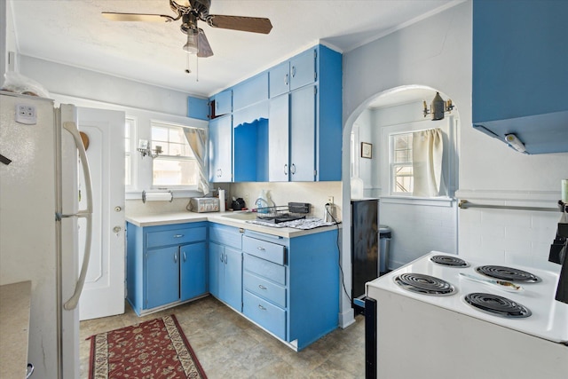 kitchen featuring white appliances, arched walkways, ceiling fan, light countertops, and blue cabinets